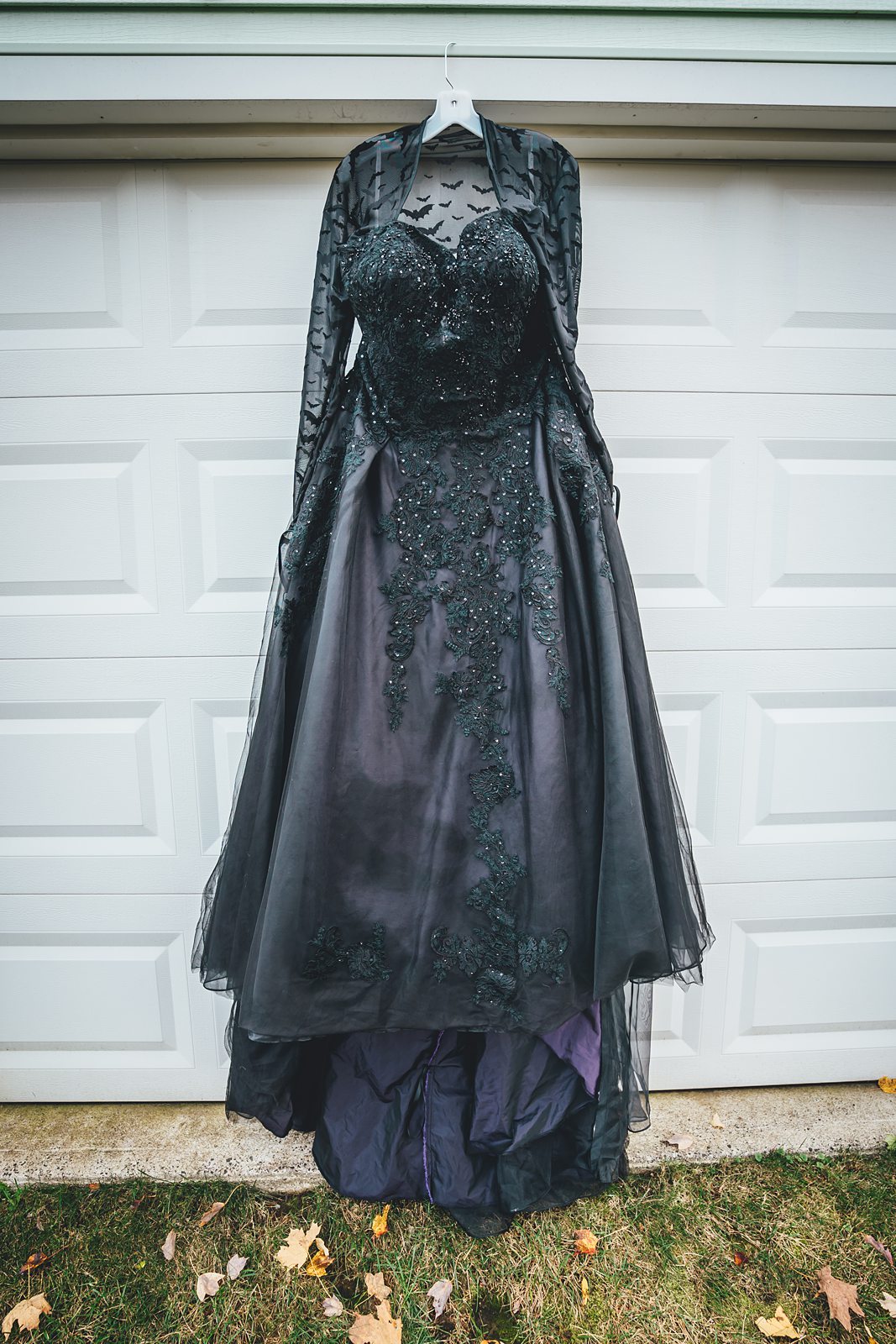 Black wedding dress detail showing bat-patterned lace sleeves