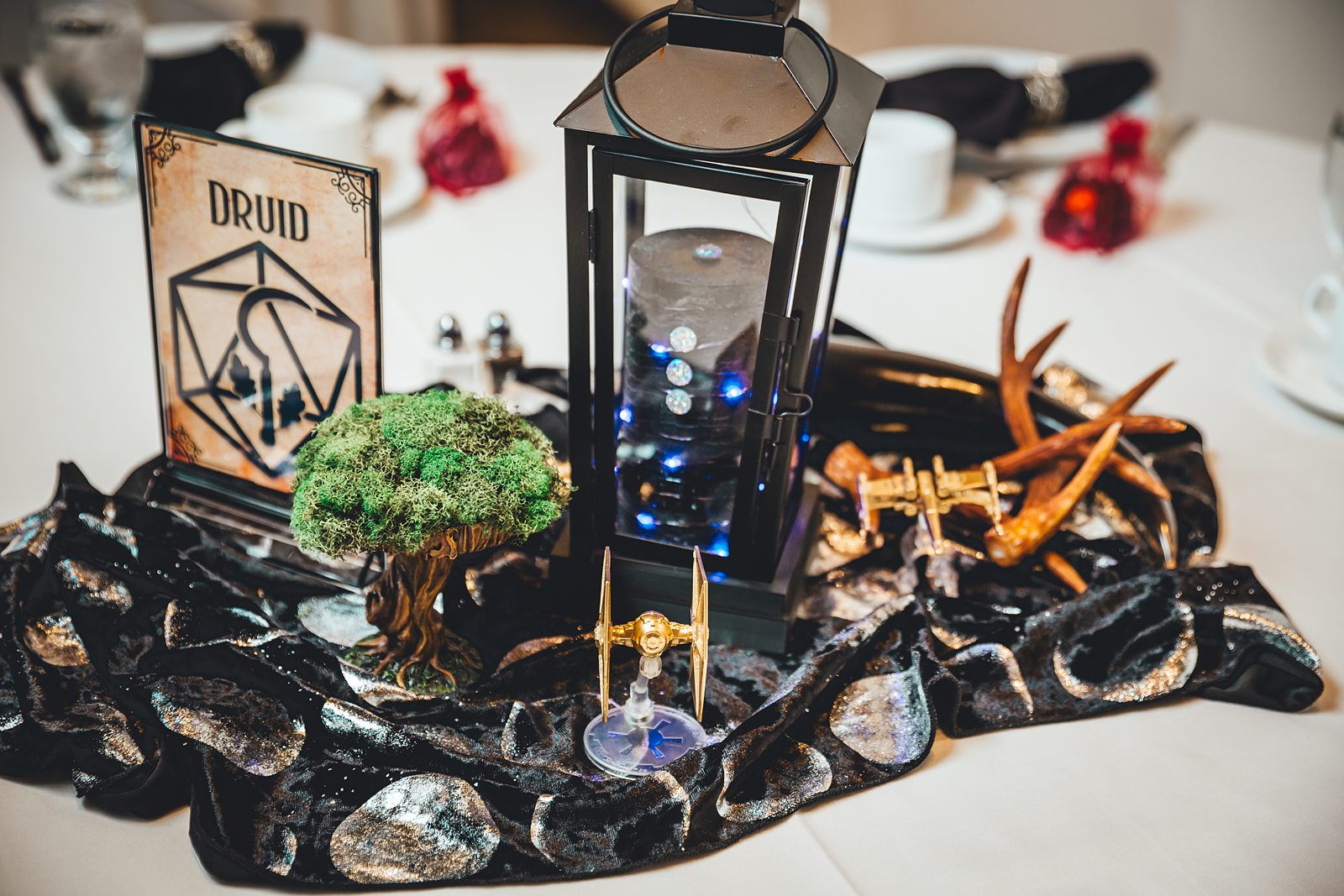Druid table centerpiece with mossy tree, antlers, and TIE fighter