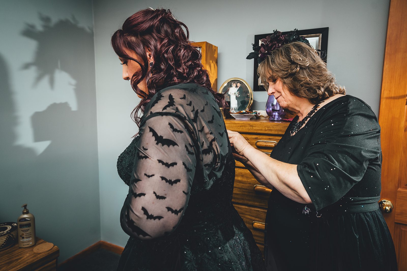 Bride getting buttoned into black wedding gown